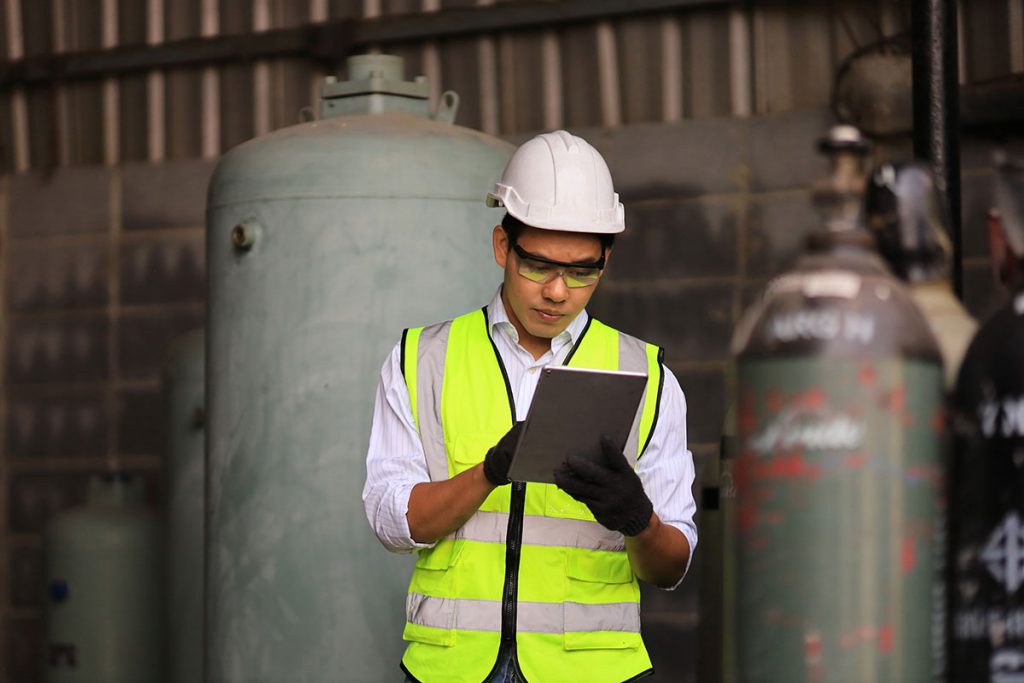 Person with tablet with gas tanks